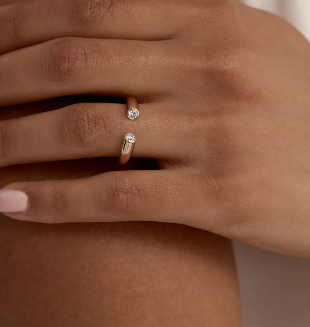 Close-up of a hand wearing two diamond rings