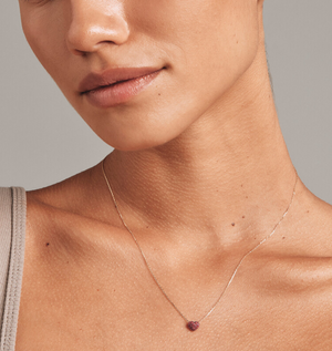 Elegant heart-shaped ruby pavé necklace in gold.