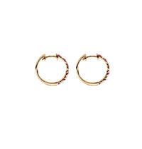 Women’s ruby huggie earrings in a hoop style.