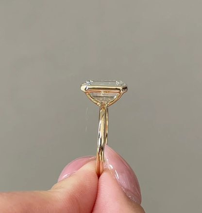 emerald cut lab grown diamond engagement ring with cathedral gold band