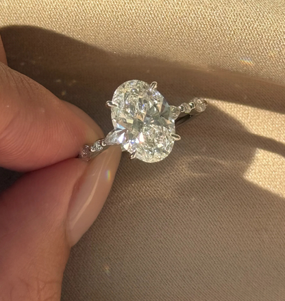 oval lab grown diamond engagement ring with round and marquise accent stones